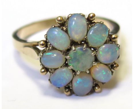 Yellow metal ring set with a floral setting of Opals size P weight 4.5 grams