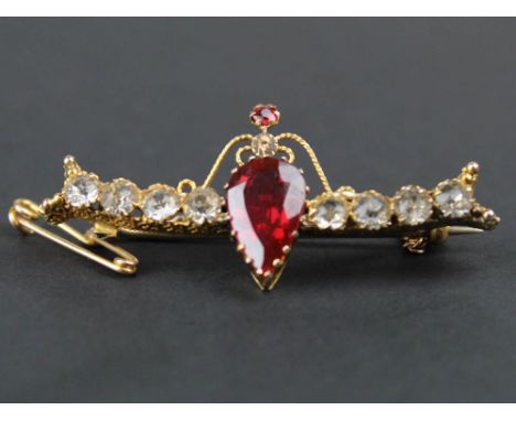 9 carat gold ruby and white coloured stones set bar brooch, centered with single pear cut red stone, flanked by a row of four