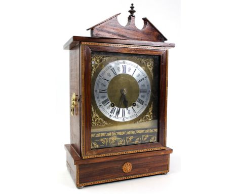 A walnut veneered early 20th century mantle clock with an eight day movement striking on a gong. Lion mask handles to either 