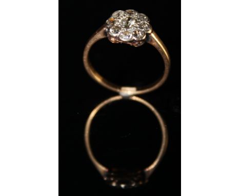 Ring stamped 18ct with 9 Diamonds set in a floral pattern size L weight 2.2 grams