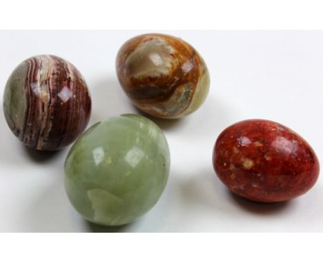Four Chinese hardstone eggs including a jade example circa 1900, all with extensive graining and patterns. The largest being 