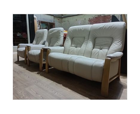 A German Himolla cream leather three piece suite comprising sofa with two matching armchairs.