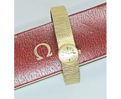 A ladies 18ct gold Omega wristwatch, signed gold dial with gold and black baton hour markers, index hands, 17 jeweller manual