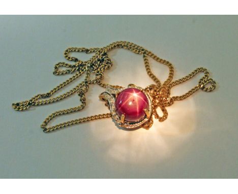 A synthetic star ruby and diamond pendant, marked '9K', on 44cm chain marked '375', gross wt. 5.2g.  