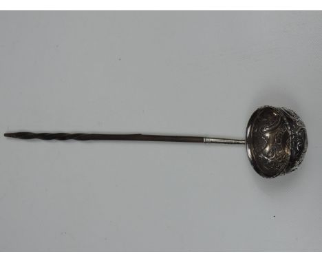 A c1800 Silver Toddy Ladle, circular bowl with embossed scroll and floral decoration, and a twisted baleen handle, typically 