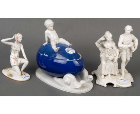   Dreitlgs. Porzellan-Konvolut des 20. Jhs.: Eidose mit Putto, Fraureuth; Art Déco-Figur, Goebel; galantes Paar Nymphenburg, 