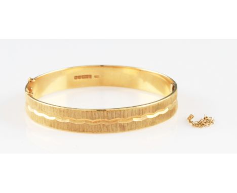A 9ct yellow gold bangle, featuring bright cut engraved design to entire circumference, hallmarked Birmingham 1972, safety ch