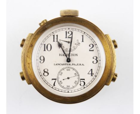 A WW2 US Navy marine chronometer by Hamilton, having brass body with white face with black Arabic numeral hourly markers with