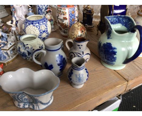 An oriental ceramic wide vase and four blue oriental jugs.