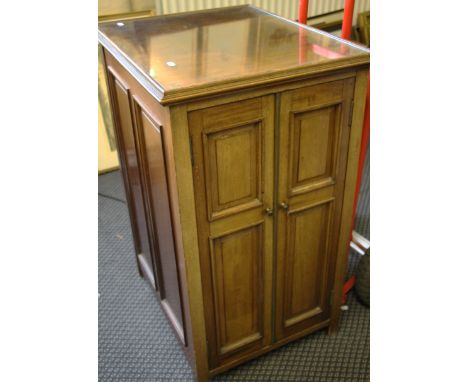 A mahogany music cabinet with two panelled doors with compartments with another door to rear with single shelf to inside.