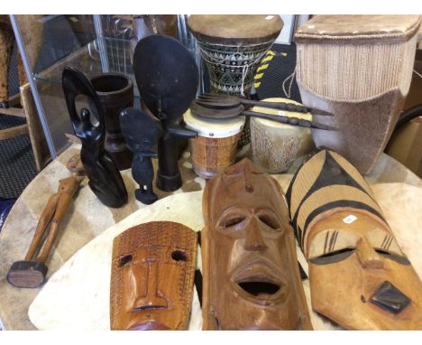 A collection of wooden African tribal items, to include 3 masks, a selection of figurines, a carved detailed goblet, a fork a