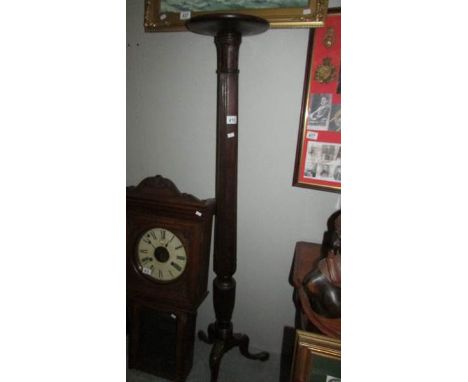 A mahogany torchere on tripod base