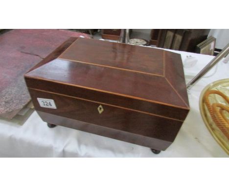 An early Victorian mahogany tea caddy with boxwood stringing