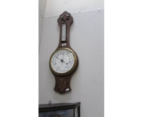 A carved oak barometer