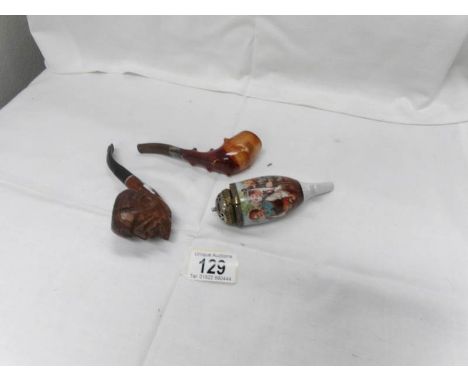 A carved wood pipe, an Austrian ceramic pipe and one other