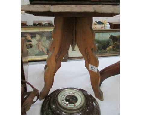 A carved wood table on tripod base