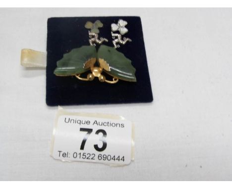 A jade brooch fashioned as a butterfly in yellow metal and a pair of silver earrings