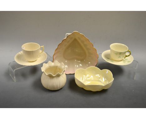 A Belleek porcelain coffee cup and saucer, moulded and painted with shamrock; a Belleek love heart shaped dish; a vase, cup a