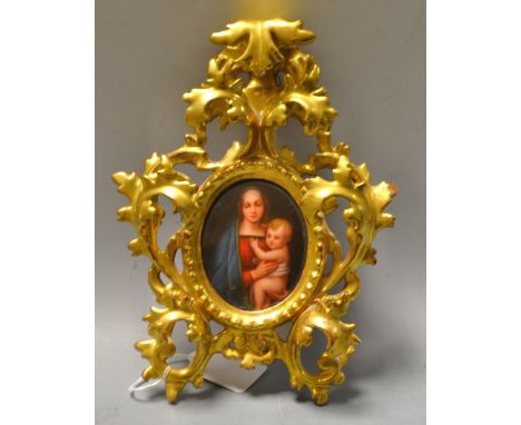 A continental hand painted oval portrait miniature, The Madonna and Child, ornate leafy carved giltwood frame, 23cm high, pap
