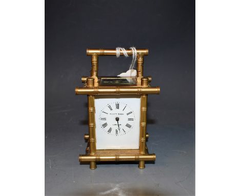 An early 20th century Elliott & Son, London brass carriage clock, bamboo edged case, Roman numerals on white dial, folding ha