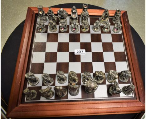 A cast pewter Lord of the Rings chess set by Danbury Mint, cased within board (missing two pieces) with certificate 3107