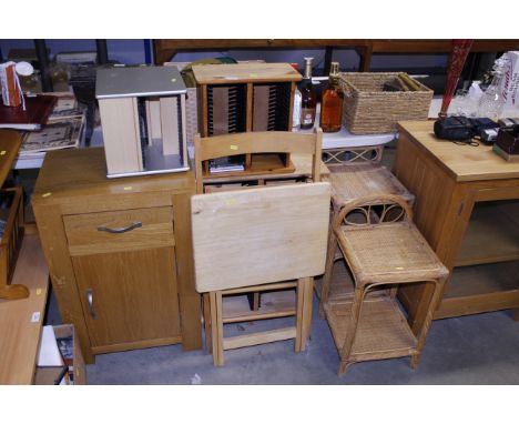 Three CD racks, a folding table, a folding slated chair and a light wood bedside cupboard