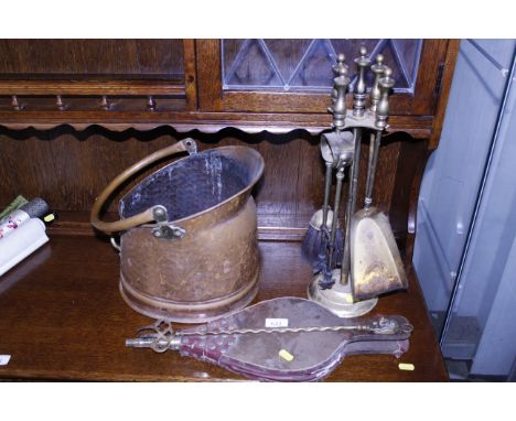 A copper coal scuttle; a brass companion stand; a pair of bellows and a brass toasting fork with dog handle 