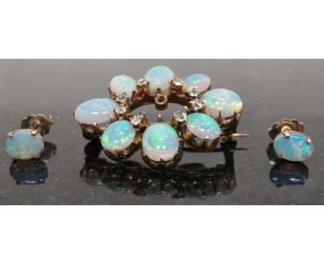 A Vintage Opal Brooch and Earrings:
an oval cabochon opal and diamond set brooch with matching opal earrings.   High transluc