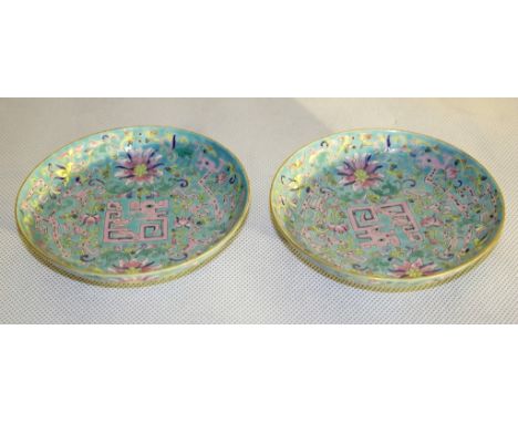A Pair of 19th Century Famille Rose Saucers:
the inside and outside decorated with stylised dragons amongst flowering scrolls