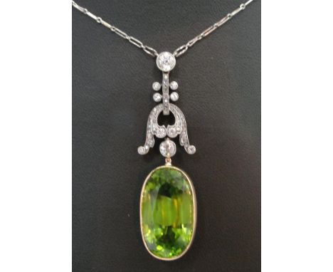 A 19th Century Diamond and Peridot Necklace:
a white gold chain with diamond set fancy pendant in white gold suspending a 23.