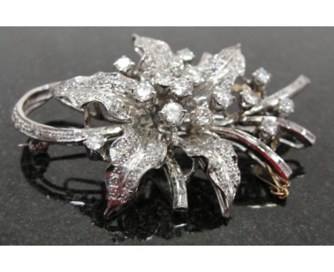 A 14k Diamond Set Floral Brooch:
an Art Deco-style 14k brooch set with eight cut and brilliant cut and baguette diamonds on p