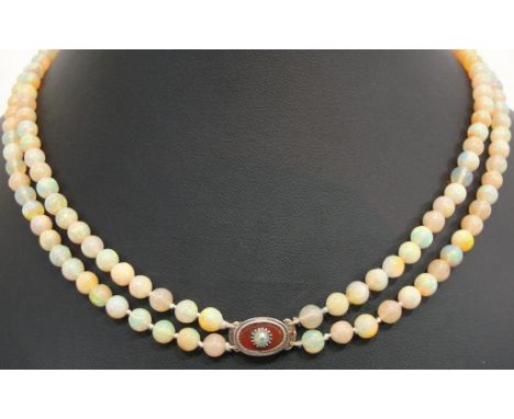 A Twin-Strand Opal Bead Necklace:
a twin-strand necklace with cornelian and pearl set clasp comprising 150 approx 4mm opal be