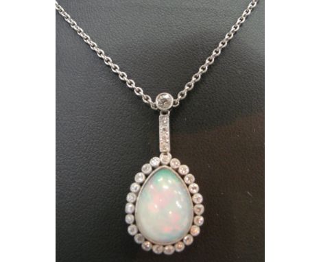 An Edwardian Opal and Diamond Pendant:
a large pendaluque cabochon opal of high translucence surrounded by old cut diamonds w