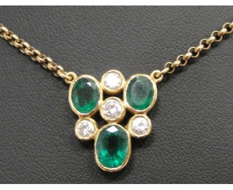 A Diamond and Emerald Set Necklace:
set with three oval cut emeralds and four brilliant cut diamonds on a 9ct belcher and bar