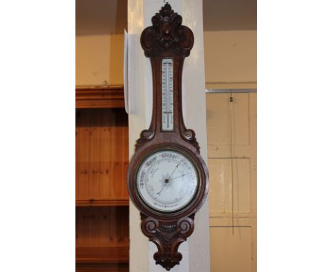 A carved oak banjo aneroid barometer with detachable thermometer 90cm