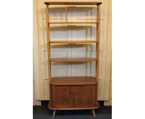 An Ercol 'Giraffe' room divider, the top shelf with spindled centre, and two further adjustable shelves, joined by four cylin