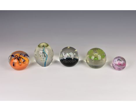 A small collection of glass paperweights, comprising three Caithness paperweights to include Morning Dew, Helter Skelter and 