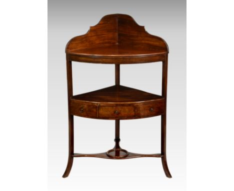 A George III mahogany corner washstand, the shaped back over a later bowfront shelf and conforming undertier with single draw