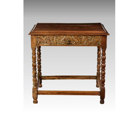 An 18th century and later stripped oak side table, with bevel moulded top over a single drawer with carved foliage, raised on