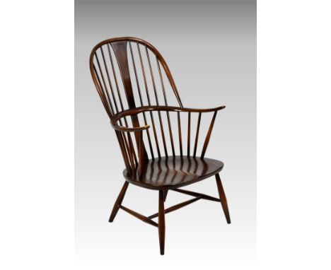 An Ercol comb-back double bow 'Chairmakers' Windsor armchair, with shaped seat, factory 'Reg. Des' stamp and original foil la