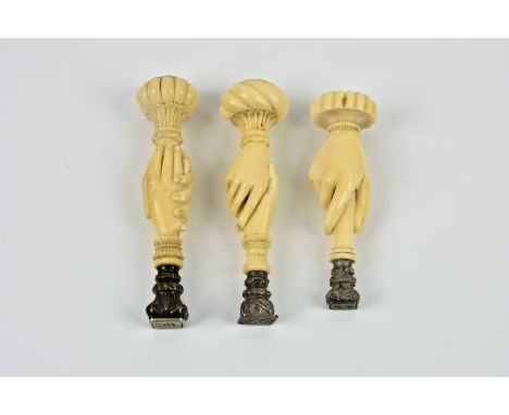 Two very fine quality ivory desk seals of clasped hands design, 19th century, both having melon top, one with vertical sectio