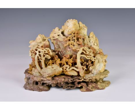 A Chinese soapstone mountain carving, first half 20th century, in russet, mutton fat and light ochre stone, finely carved wit