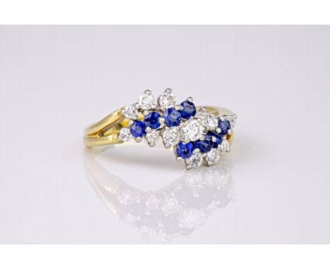 A yellow gold, diamond and sapphire ring, featuring alternating rows of undulating round brilliant cut diamonds and sapphires