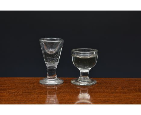 Two 19th century deceptive firing glasses, the first with cup bowl on capstan stem and plain foot, 7.1cm. high; the second wi