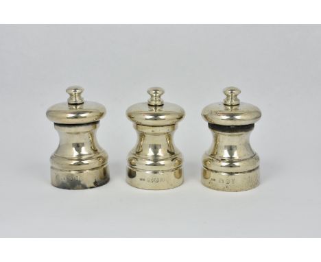 Two silver "Peter Piper" salt mills and a pepper mill, John Bull, London, 1987, the mechanism to bases inscribed " Peter Pipe