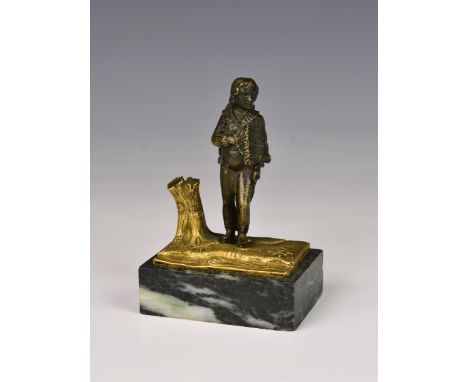 A parcel gilt bronze figure, possibly Russian, of a young gentleman with sword, his satchel with single headed eagle emblem, 