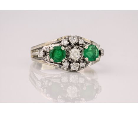 A French 18ct white gold, emerald and diamond ring, mid-century, set with two round cut emeralds and cushion, rose and eight 