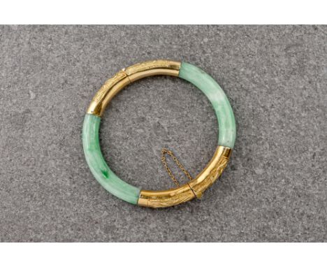 A Chinese jade and 18ct gold bangle, the gold clasp with ornate bamboo design and the jade of pale green colouring.