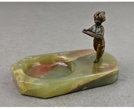 A cold painted bronze model of a Blackamoor child bearing a letter tray, standing on a dished onyx base, probably used as a d