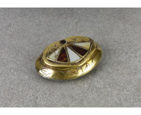 A 19th century brass snuff box of scallop shaped form, engraved with a foliate design, the lid inlaid with a fan of alternate